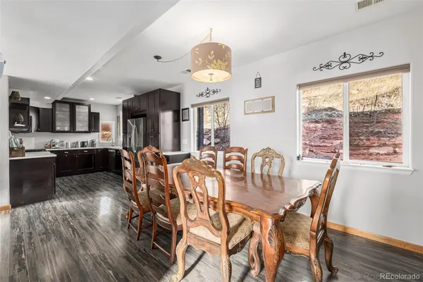 a view of a dining room with furniture a chandelier and wooden floor