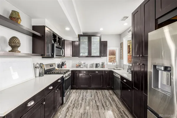 a kitchen with stainless steel appliances granite countertop a sink stove and refrigerator