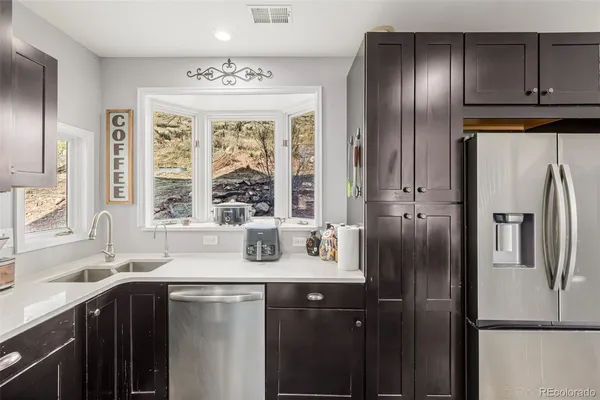 a kitchen with stainless steel appliances granite countertop a refrigerator and a sink