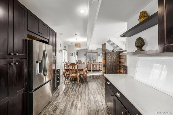 a kitchen with stainless steel appliances a dining table chairs and a refrigerator