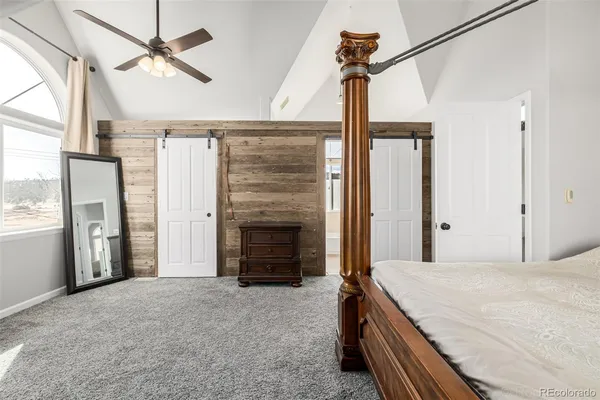 a view of a bedroom with a bed and wooden floor