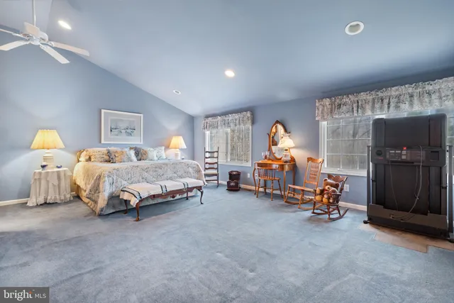 a spacious bedroom with a bed and a tv