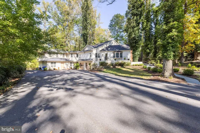a view of a house with a yard and large trees