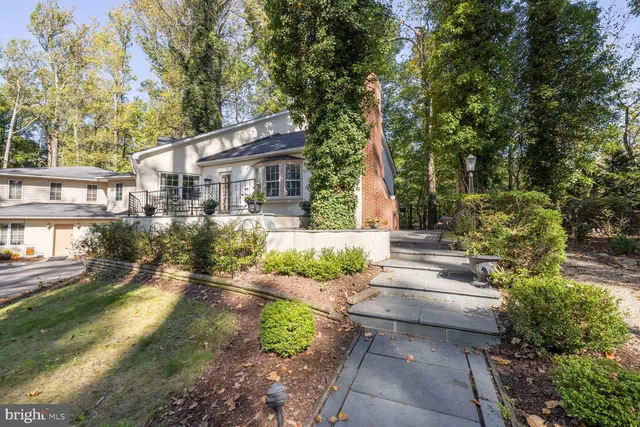 a front view of a house with a yard and potted plants