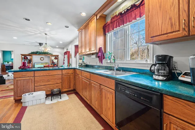 a kitchen with stainless steel appliances granite countertop a sink dishwasher and cabinets with wooden floor
