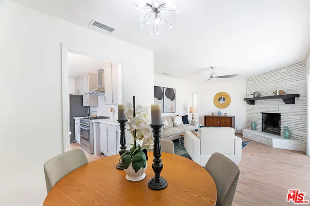 a kitchen with stainless steel appliances a sink a stove a table and chairs