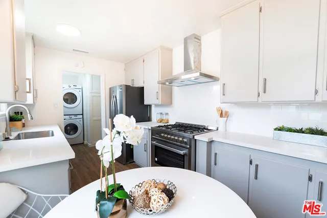 a kitchen with stainless steel appliances a white table and cabinets