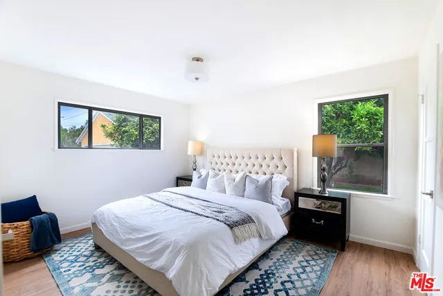 a bedroom with a bed and a lamp on dresser