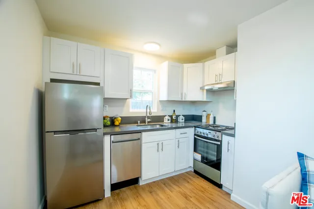 a kitchen with a sink a stove and cabinets