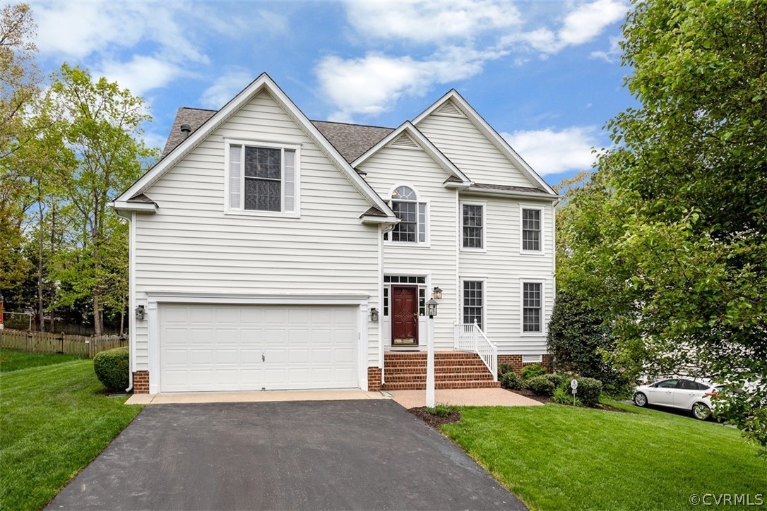 a view of a white house next to a yard and large trees