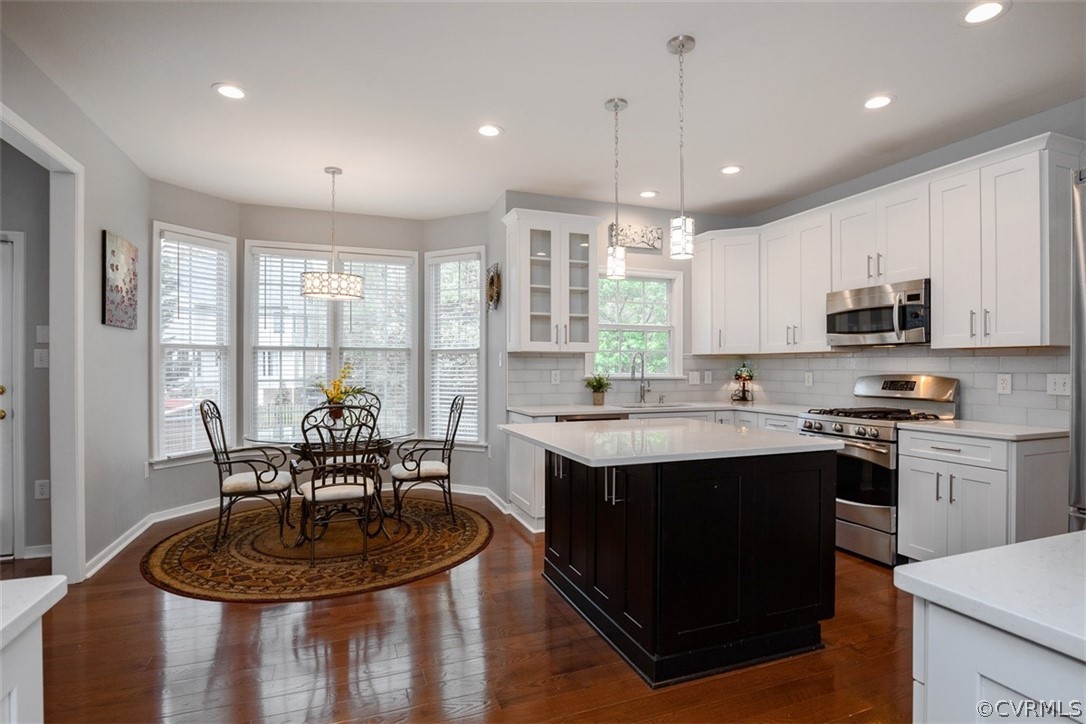 5208 Wheat Ridge Place Glen Allen, VA 23059 - Photo 15 of 45 a kitchen with kitchen island granite countertop a sink a stove a dining table and chairs
