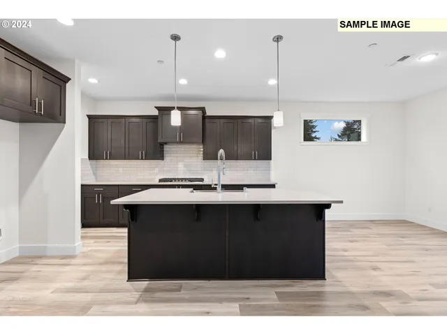 a kitchen with stainless steel appliances granite countertop a sink a stove and a wooden floors