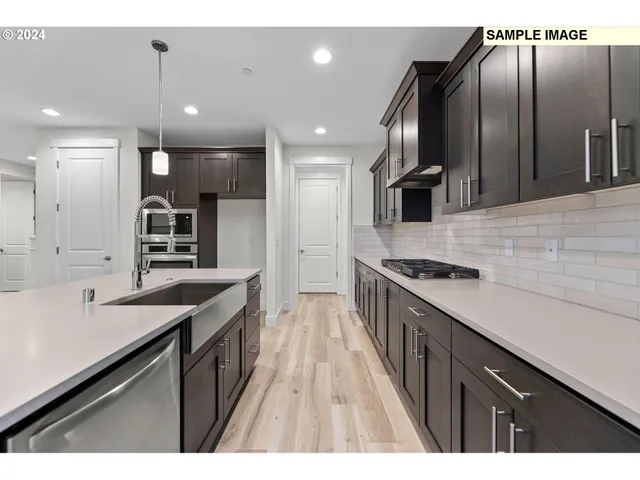 a kitchen with kitchen island a sink stainless steel appliances and cabinets