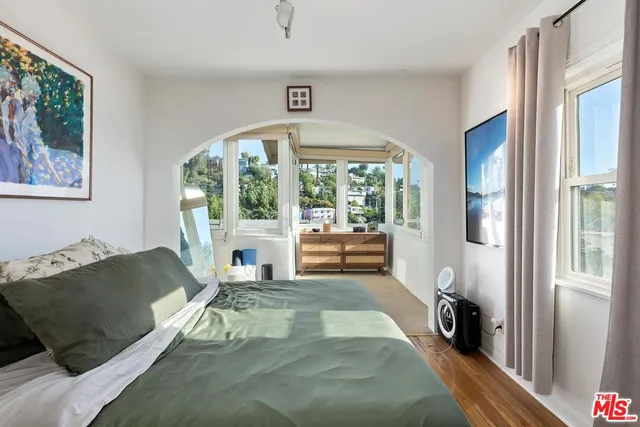 a bedroom with a bed and wooden floor