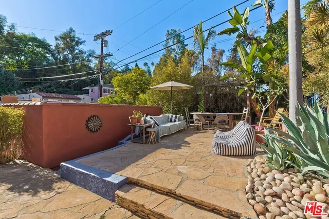 a front view of a house with a yard and potted plants