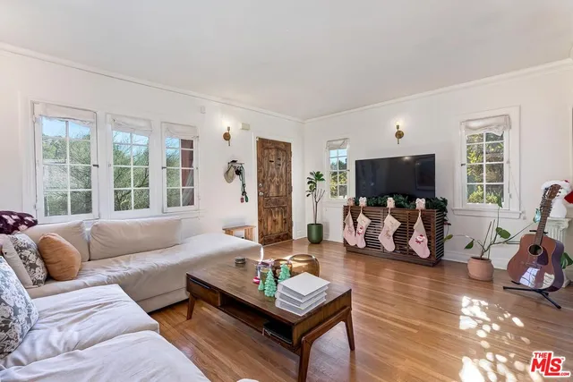 a living room with furniture a flat screen tv and a large window