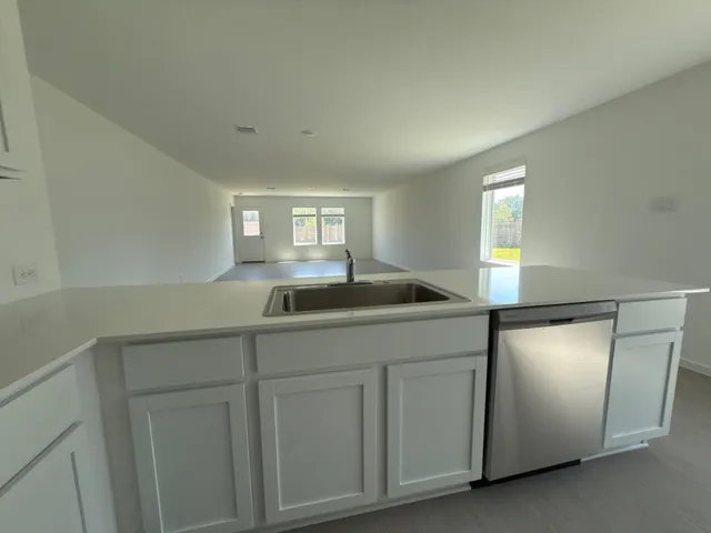 a kitchen with white cabinets and sink