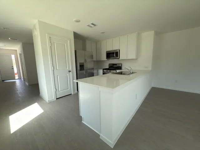 a kitchen with furniture a refrigerator and a stove top oven