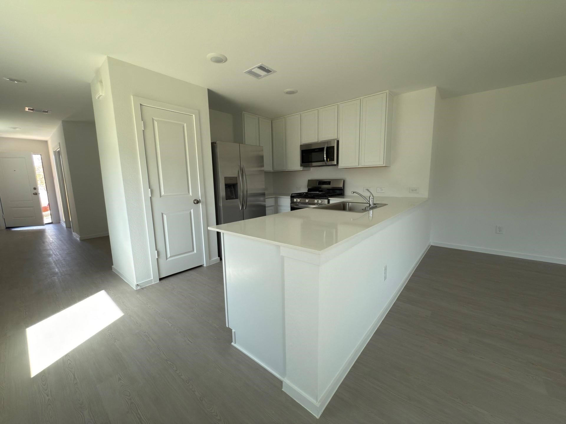 3606 Atlas Pt Lane Angleton, TX 77515 - Photo 4 of 19 a kitchen with furniture a refrigerator and a stove top oven