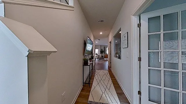 a view of a hallway with wooden floor and staircase