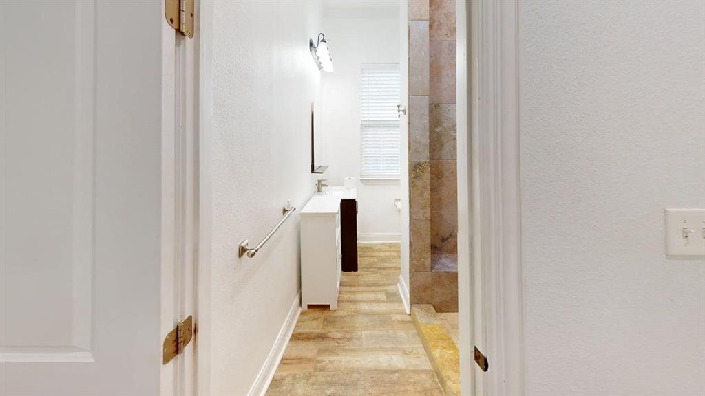 4523 Sycamore Street Dallas, TX 75204 - Photo 11 of 16 Bathroom featuring a single vanity with a white countertop, wall-mounted mirror, and overhead lighting