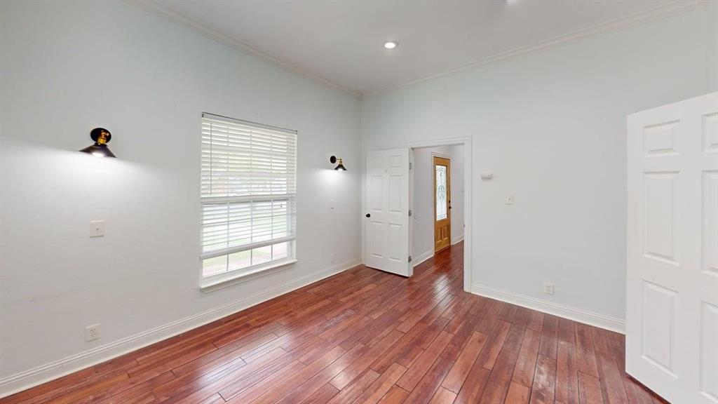 4523 Sycamore Street Dallas, TX 75204 - Photo 9 of 16 Room featuring rich wood-finish flooring, white baseboards, and a single window with blinds