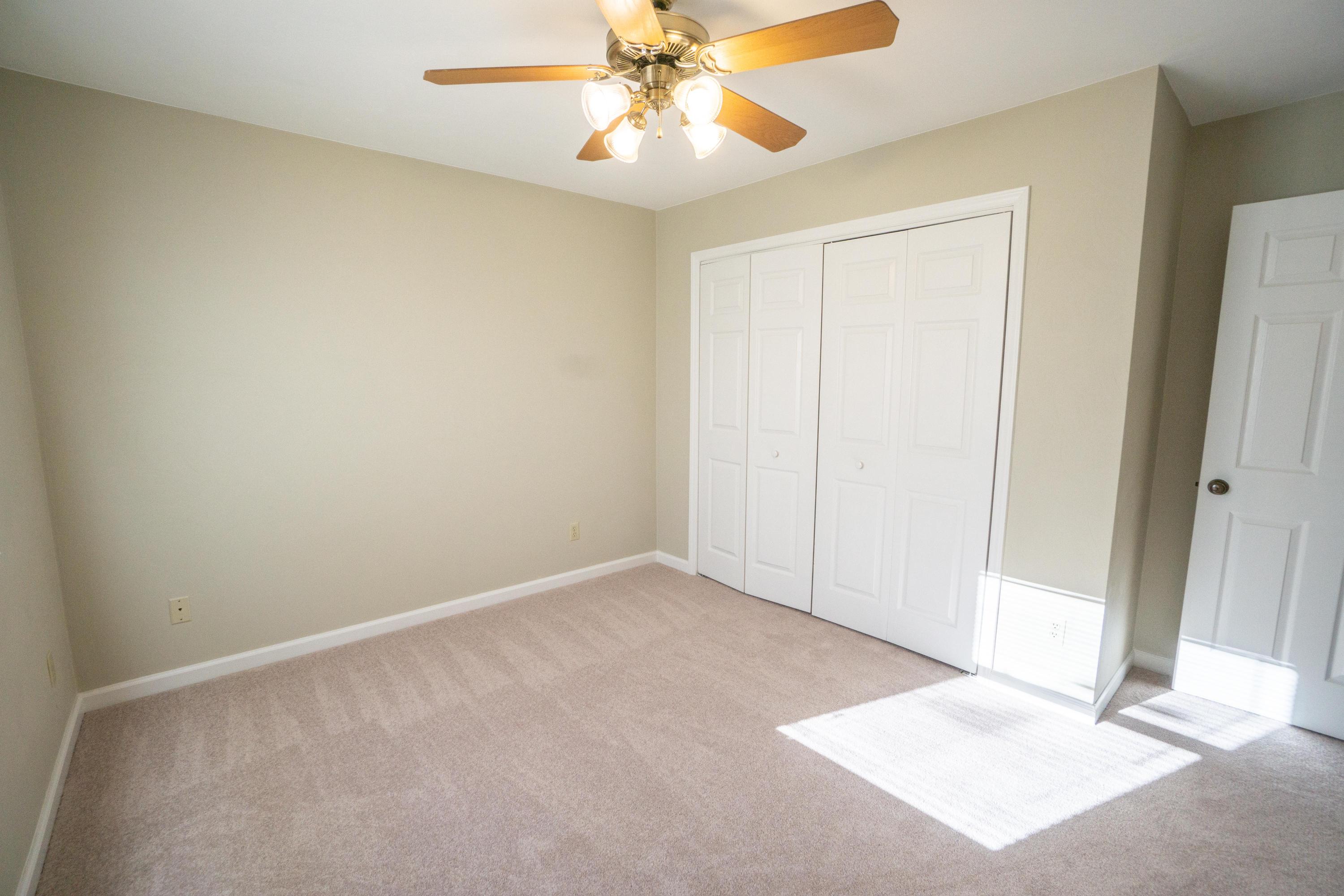 218 Oak Ridge Court Blue Ridge, VA 24064 - Photo 33 of 48 an empty room with a chandelier fan and windows