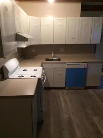 a kitchen with stainless steel appliances granite countertop a sink stove and white cabinets