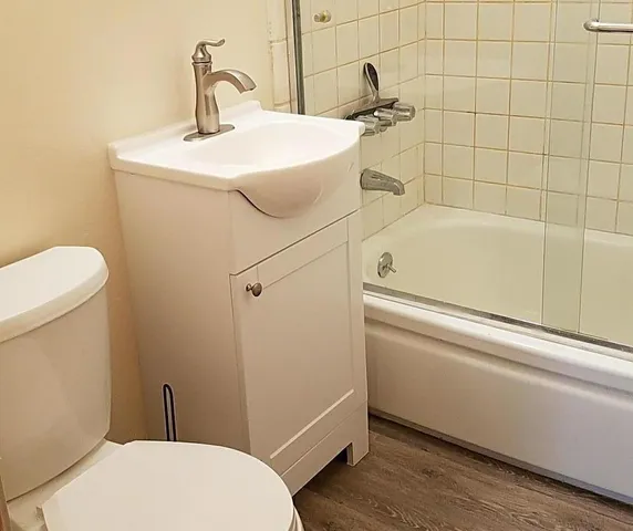 a bathroom with a sink a toilet and shower