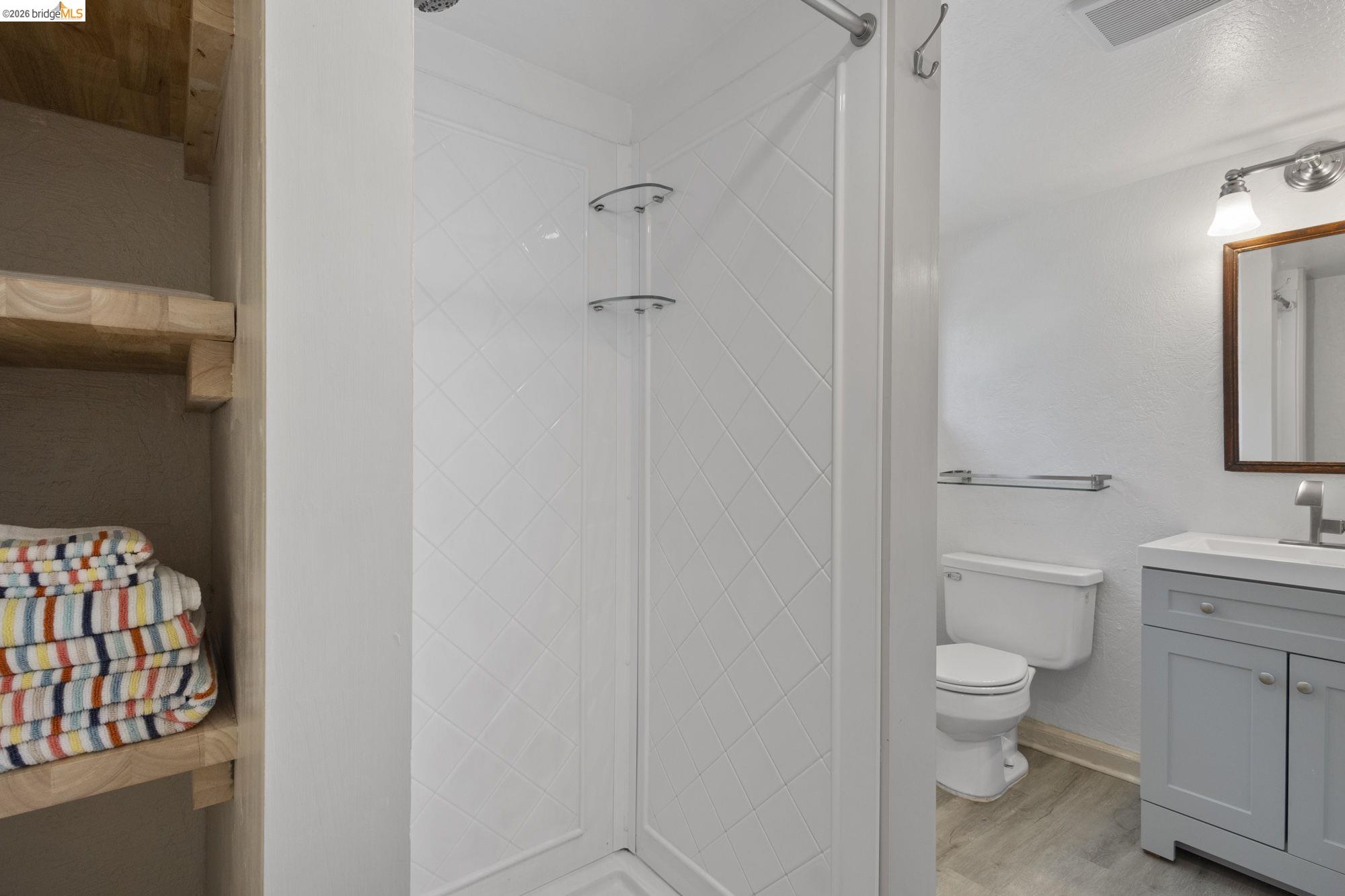 18363 Yosemite Road Tuolumne, CA 95379 - Photo 26 of 34 Shower enclosure with diagonally-patterned white tile walls and a glass door
