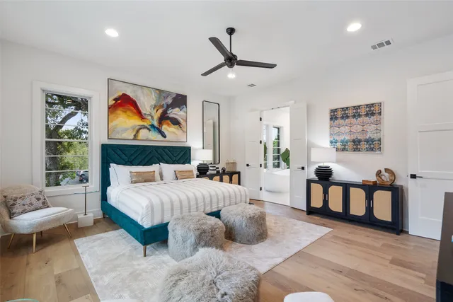 a spacious bedroom with a bed a couch and a painting on the wall