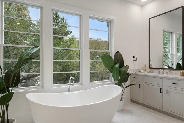 a white bath tub sitting in front of a window