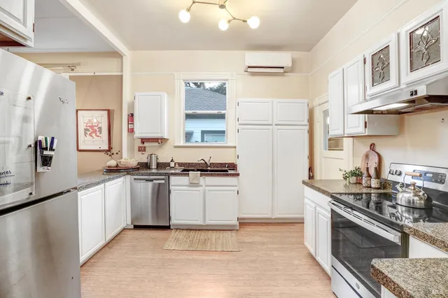 a kitchen with stainless steel appliances granite countertop a sink stove and refrigerator