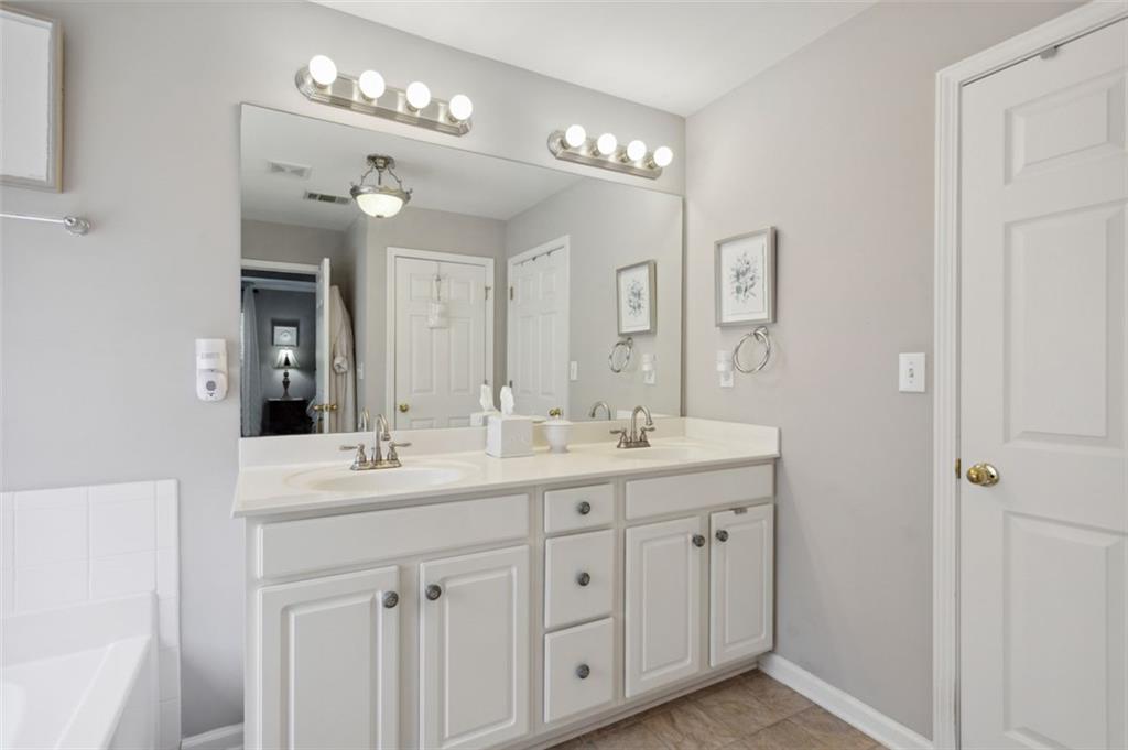 a spacious bathroom with double vanity a and a mirror