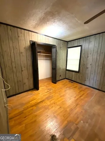 a view of empty room with wooden floor