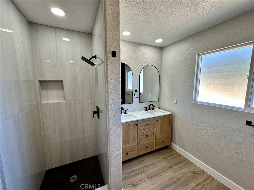 625 Tamarack Road Pinon Hills, CA 92372 - Photo 16 of 27 a spacious bathroom with a granite countertop sink a mirror and shower