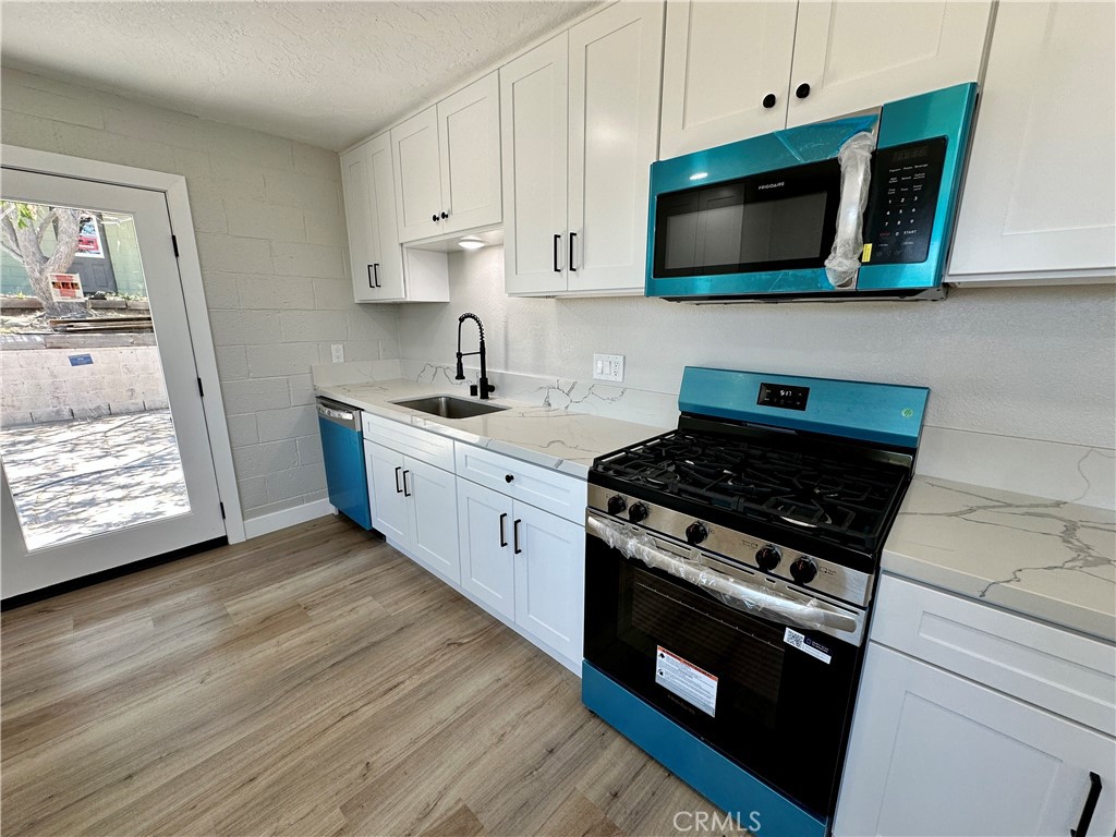 625 Tamarack Road Pinon Hills, CA 92372 - Photo 5 of 27 a kitchen with stainless steel appliances a stove a microwave and cabinets
