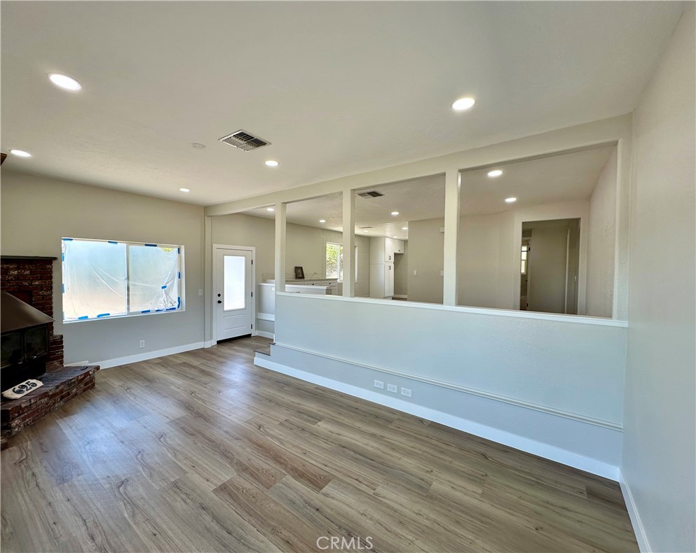 625 Tamarack Road Pinon Hills, CA 92372 - Photo 6 of 27 a view of an empty room with wooden floor and a window