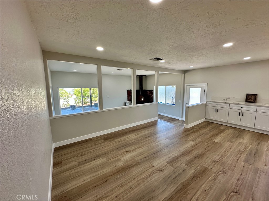 625 Tamarack Road Pinon Hills, CA 92372 - Photo 8 of 27 an empty room with wooden floor and windows