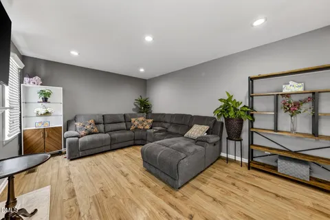 a kitchen with kitchen island a stove a refrigerator and a dining table with wooden floor