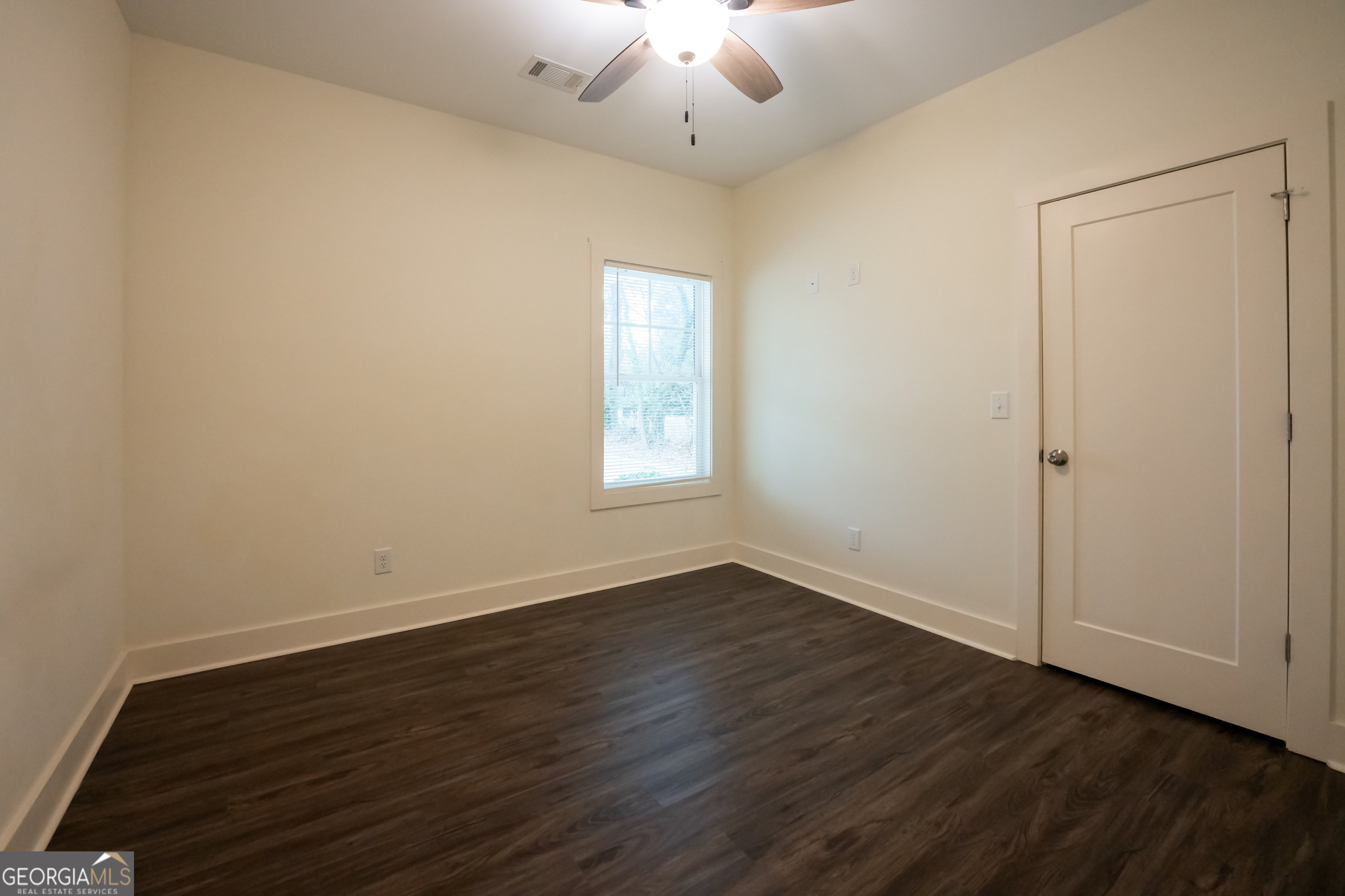 1020 Bell Circle Madison, GA 30650 - Photo 13 of 17 an empty room with wooden floor chandelier and window