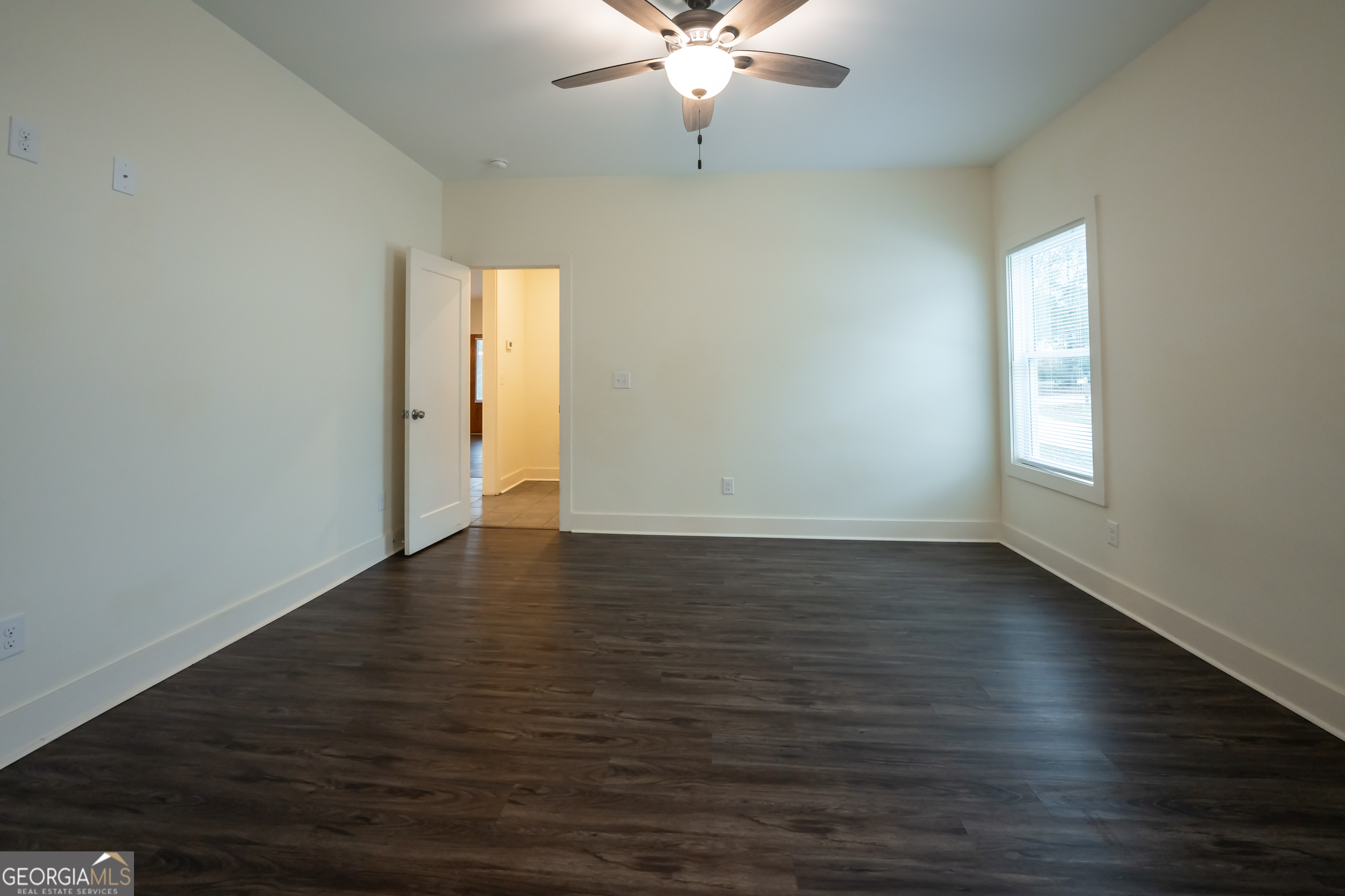 1020 Bell Circle Madison, GA 30650 - Photo 8 of 17 an empty room with wooden floor and windows