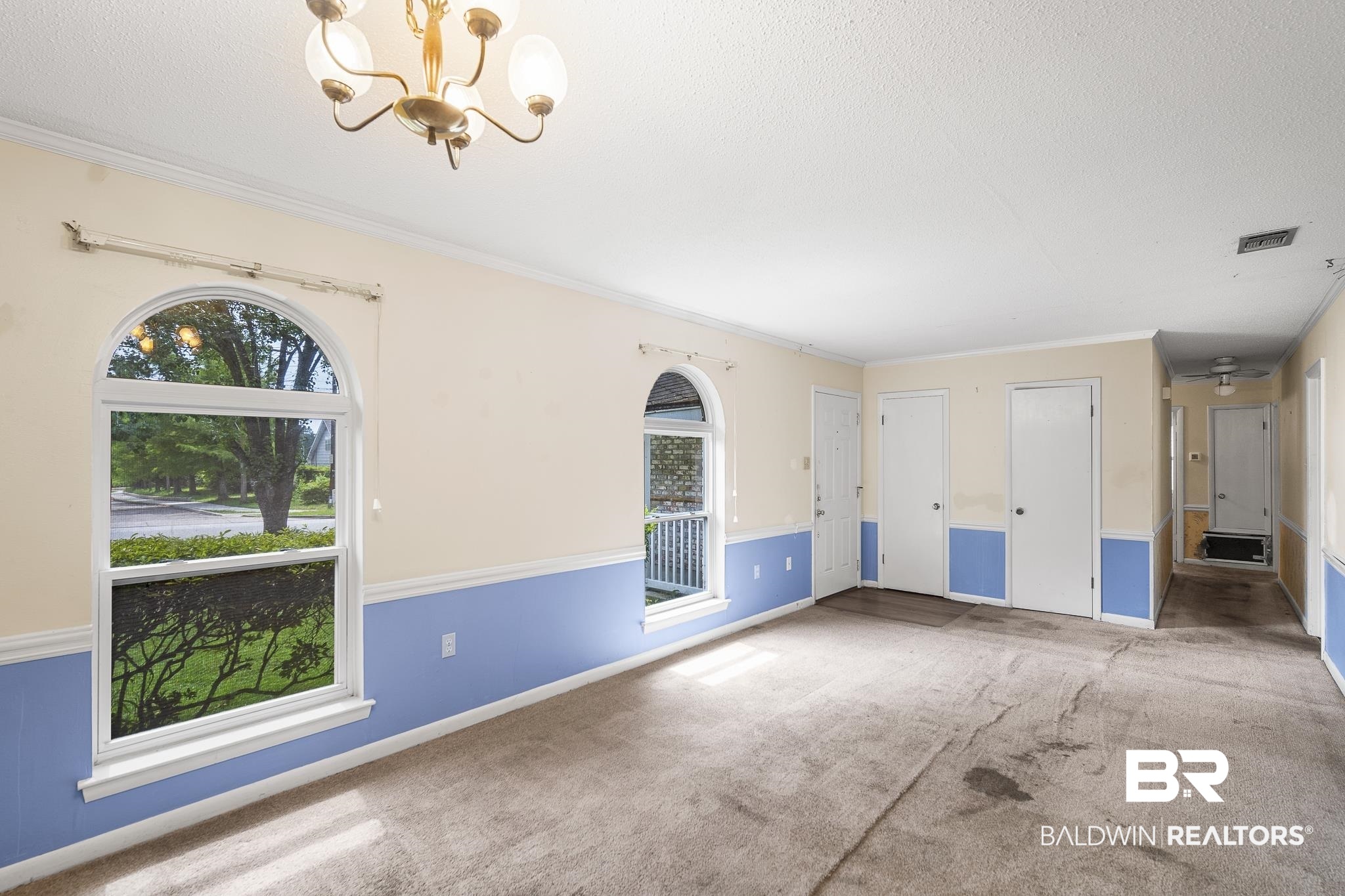 2710 Longleaf Drive Mobile, AL 36693 - Photo 7 of 27 Interior space with a healthy amount of sunlight, a notable chandelier, carpet floors, and crown molding