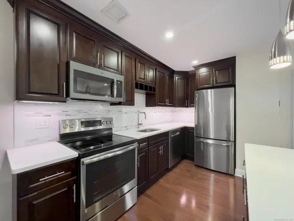a kitchen with granite countertop stainless steel appliances and wooden cabinets
