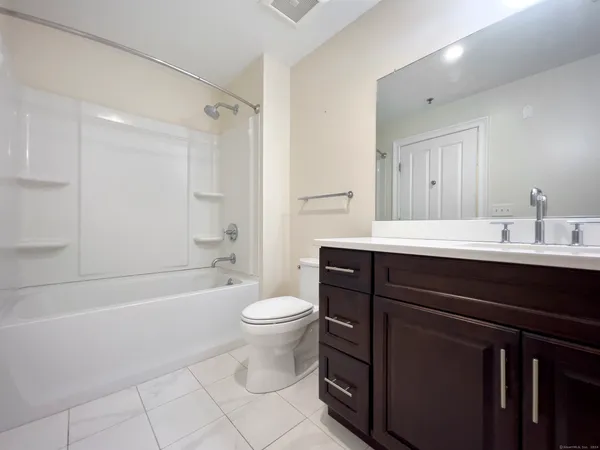 a bathroom with a sink a toilet a mirror and bathtub