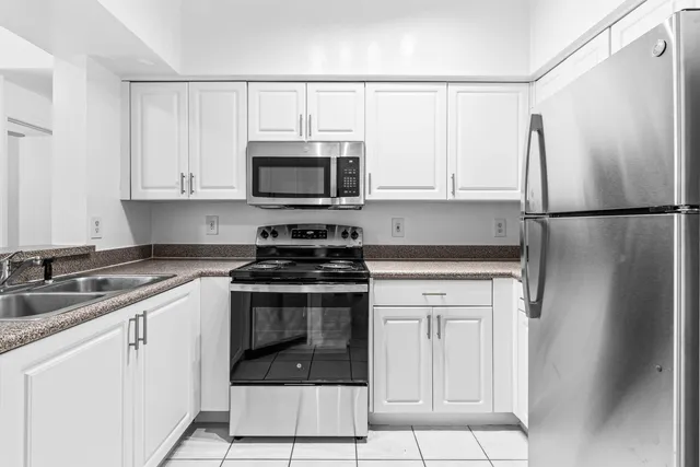 a kitchen with cabinets stainless steel appliances and a sink