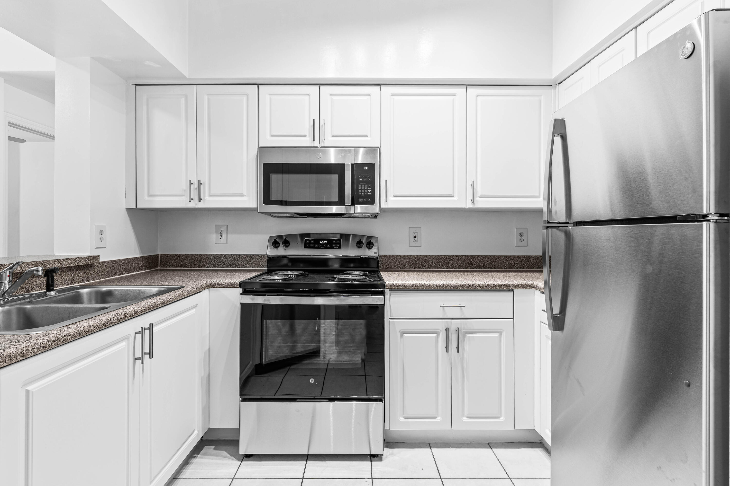 1951 Brandywine Road East, Unit 77105 West Palm Beach, FL 33409 - Photo 1 of 35 a kitchen with cabinets stainless steel appliances and a sink
