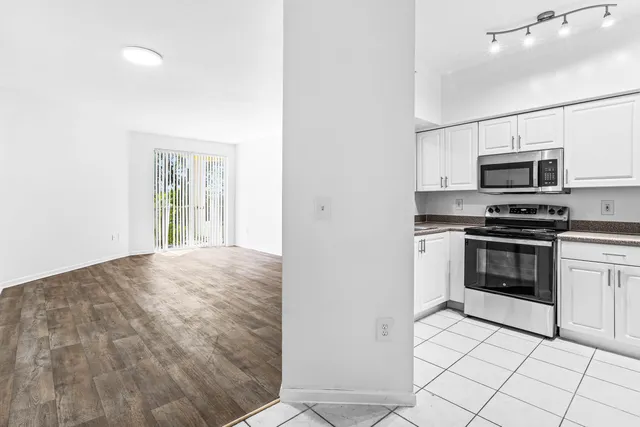 a kitchen with kitchen island a stove and a microwave
