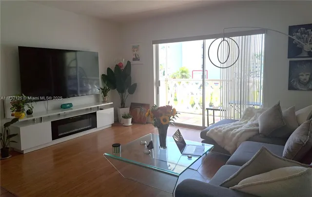 a living room with furniture a window and a flat screen tv