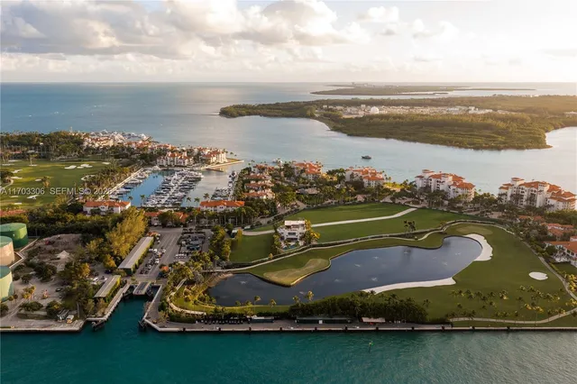 an aerial view of a city with lots of residential buildings ocean and mountain view in back